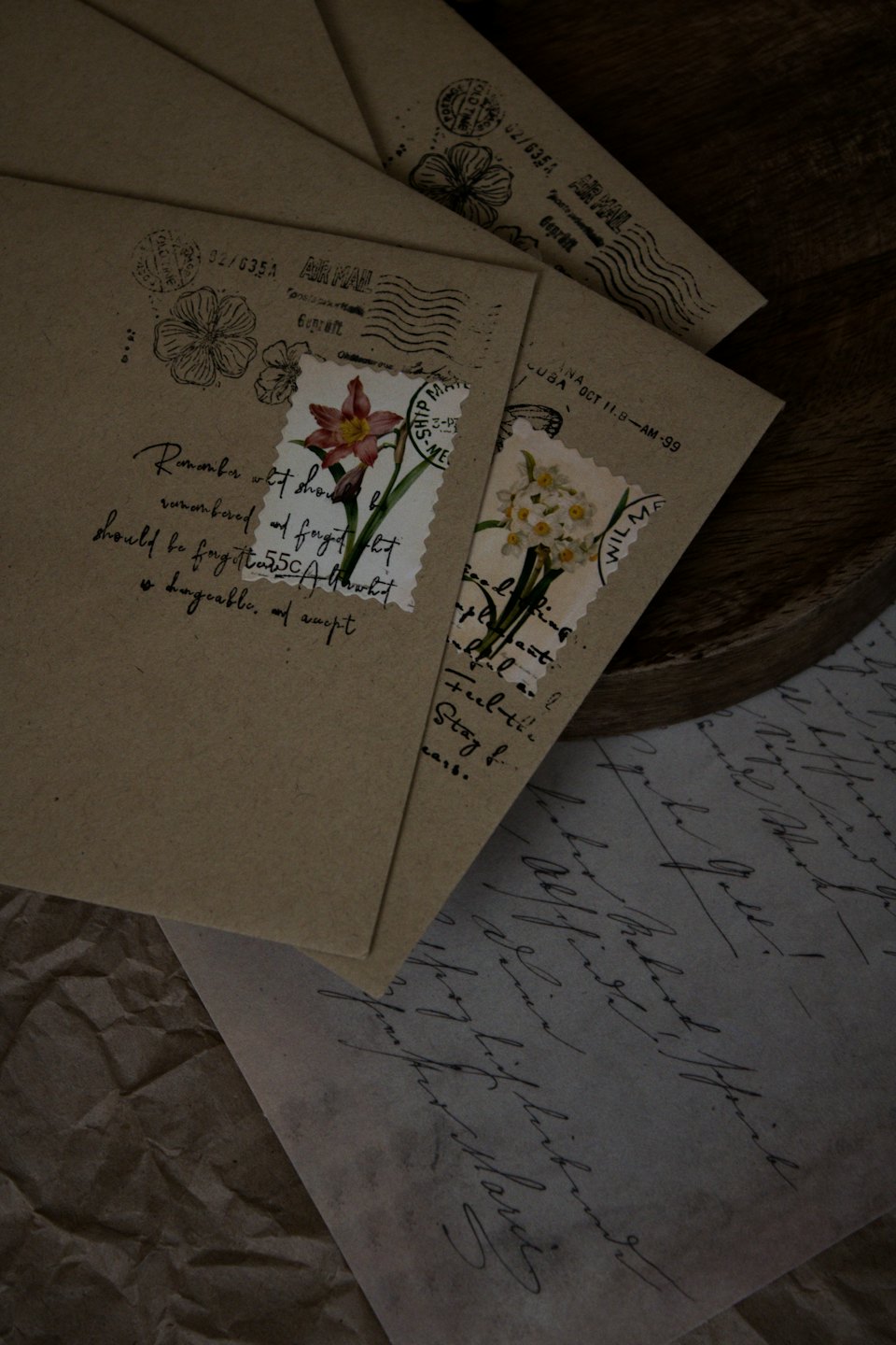 Stack of vintage kraft envelopes with flower stamps and cursive letters.