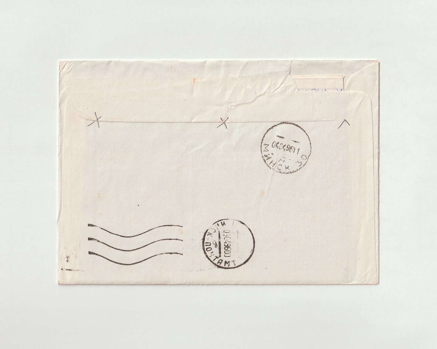 Worn vintage envelope with stamps and cancellation marks on white.