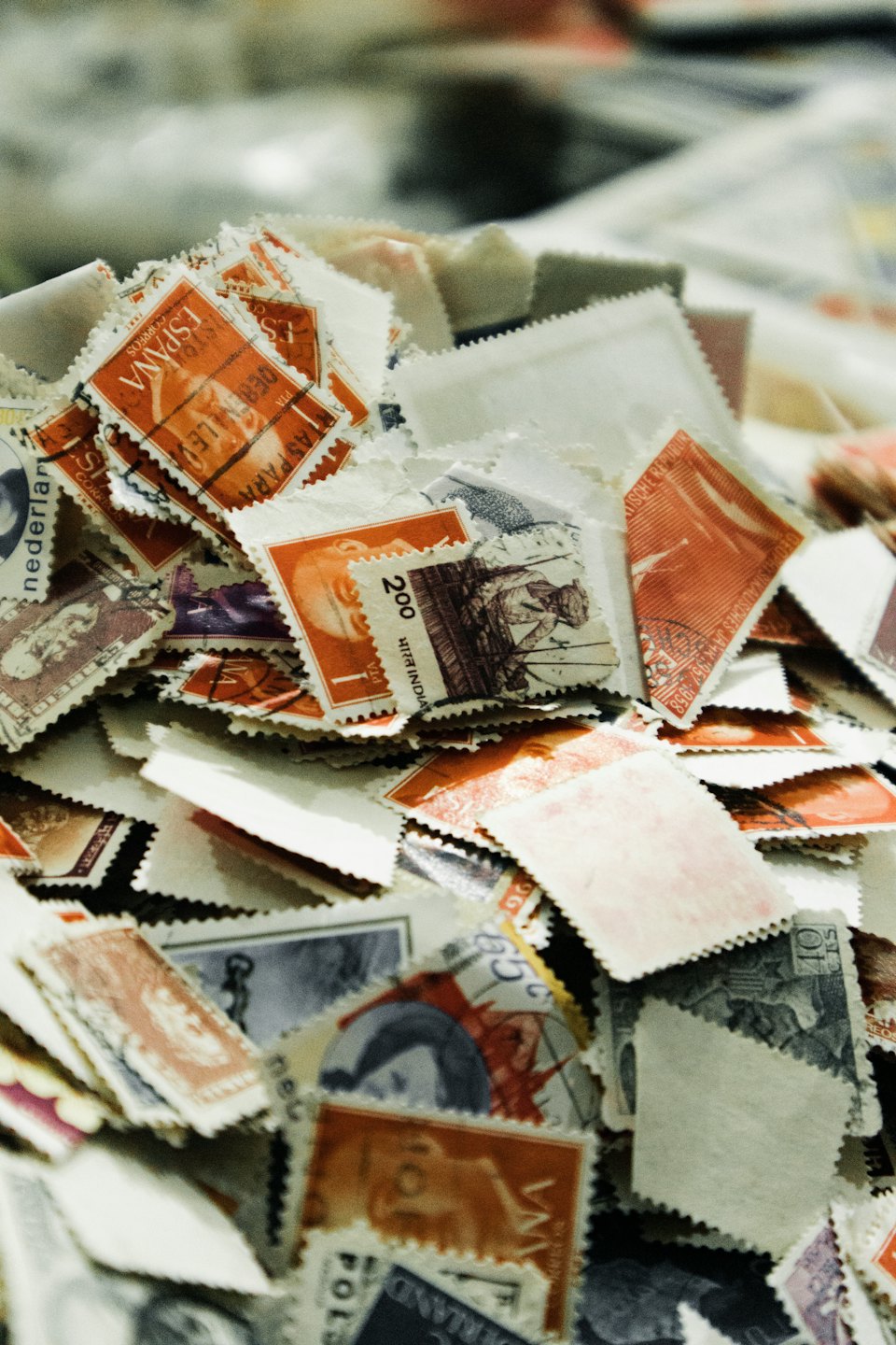 A large pile of assorted vintage postage stamps from different countries.